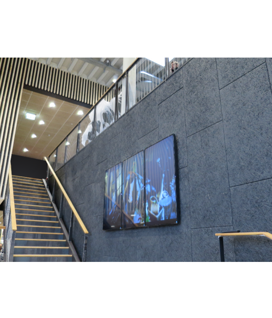 Unifi+ e un monitor in una biblioteca posizionato su una parete di una scalinata.