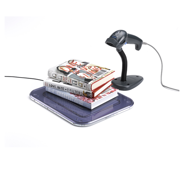 La postazione Rfid workstation shielded: tre libri sono appoggiati sopra a una piccola piastra schermata con angoli smussati e accanto c'è un lettore barcode.